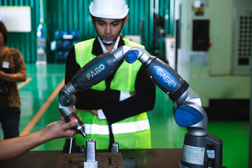 Asian engineers male female in Industrial wear hard hats in Industry manufacturing factory mechanical display interface arm robot manufacturing industry engineer technology