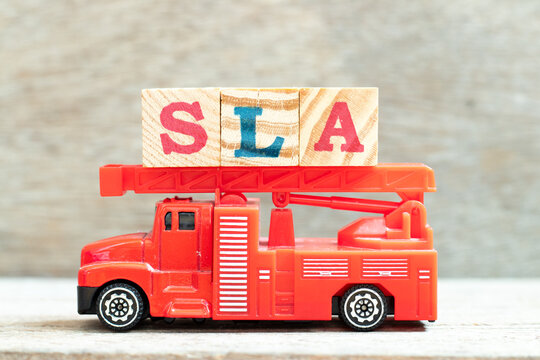 Fire ladder truck hold letter block in word SLA (Abbreviation of Service level agreement) on wood background