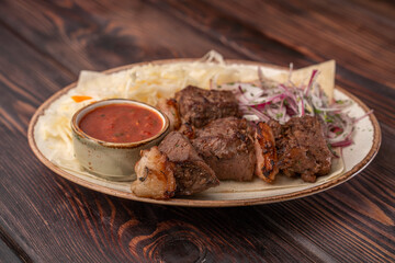 Juicy grilled BBQ meat with salted cabbage, onions and tomato sauce
