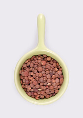 Small trial portion of red lentils on platter isolated on white background. Design element with clipping path