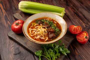 lagman with beef in tomato sauce in a deep plate, photo for the menu