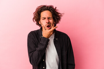 Young caucasian man isolated on pink bakcground having a strong teeth pain, molar ache.