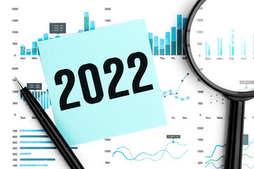 Word 2022 on sticker. Magnifier, pen and charts and graphs top view. Business and statistical...