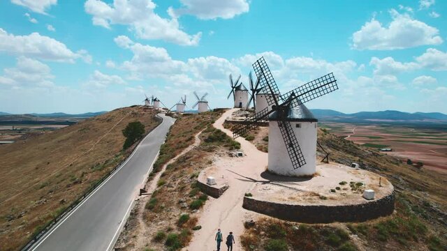 Drone point of view famous windmills in Consuegra town, symbol of Castilla-La Mancha, against fluffy cloudy sky background. History and heritage in Toledo concept. Europe, Toledo. Spain