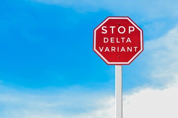 Red label on a pole with texts “Stop Delta Variant”, concept for prompting people to stop the spreading and transmitting of Corona virus Delta variant around the world