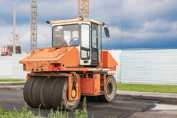 Obraz premium Heavy-duty vibratory roller for asphalt paving. Road construction. Construction of roads and urban transport communications. Heavy machinery.