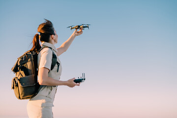 Drone launch. Young woman tourist holds a drone in his hand lifting it up. Selective focus.