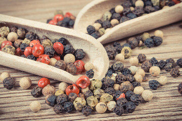 Colored pepper on wooden board as cooking spice
