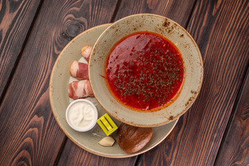 Red beet soup, borscht, with garlic, sour cream and slices of ham or lard