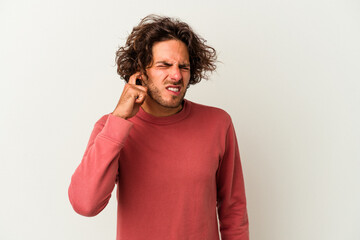 Young caucasian man isolated on white background covering ears with fingers, stressed and desperate by a loudly ambient.