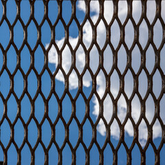 Naklejka premium texture of the sky through a metal lattice