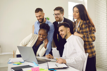 Virtual business meeting in office, young people collaboration on internet, team spacing. Multiracial diverse business people group looking at laptop screen together having online conference