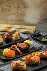 Japanese sushi set and with  shoyu soy sauce with wasabi in ceramic plate dark Placed on the table concrete grunge texture background., front view