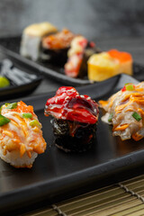 Japanese sushi set and with  shoyu soy sauce with wasabi in ceramic plate dark Placed on the table concrete grunge texture background., front view