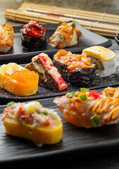 Japanese sushi set and with  shoyu soy sauce with wasabi in ceramic plate dark Placed on the table concrete grunge texture background., front view