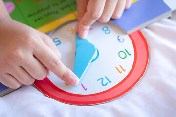 kid play telling time game, young children to learn how to read an analog clock.