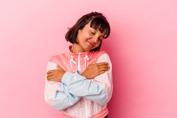 Young mixed race woman isolated on pink background hugs, smiling carefree and happy.