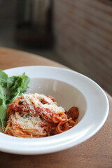 spaghetti Bolognese with italian sausage and tomato sauce with parmesan cheese and basil