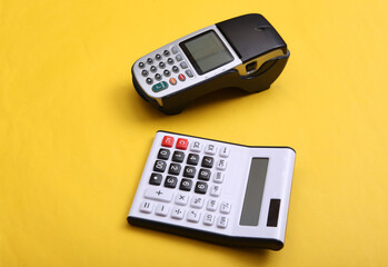 Pos terminal and calculator on yellow background.