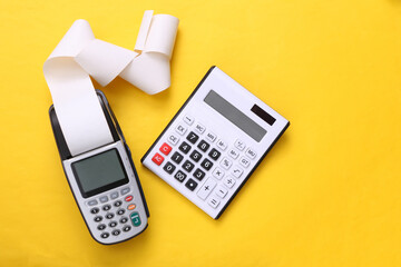 Pos terminal and calculator on yellow background.