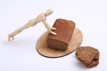 Wooden puppet  push-ups from whole grain rye bread on white background. Fitness concept