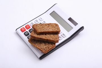 Calculator with Sliced whole grain rye bread on white background. Diet, calorie counting concept