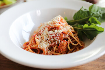 spaghetti Bolognese with italian sausage and tomato sauce with parmesan cheese and basil