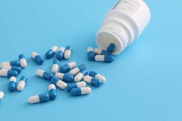 pills capsules with bottle isolated on blue background