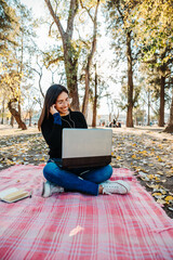 young woman using laptop to listen to music outdoors