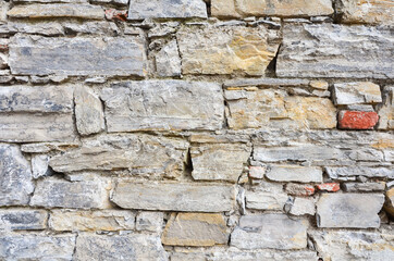Fortress wall made of stone and bricks of different shapes and colors