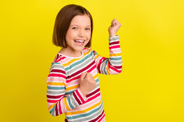 Profile photo of hooray short hairdo little girl hands fists yell wear colorful shirt isolated on vivid yellow color background