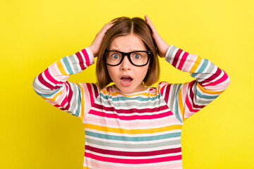 Photo of amazed shocked scared small girl hold hands head wear glasses isolated on yellow color background - obrazy, fototapety, plakaty