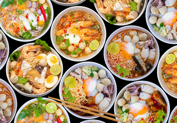 Top view noodle soups or Tom Yum is delicious , hot and spicy fast food on black background. 
