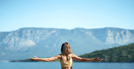 Fototapeta na wymiar Panoramic banner image woman with open arms at nature with beautiful mountains view. Calmness and harmony with nature