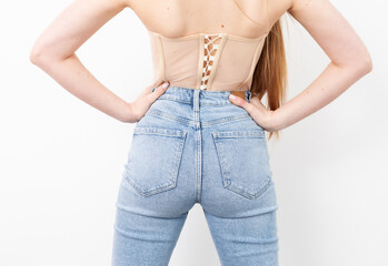 Woman's butt in tight blue jeans on a white background