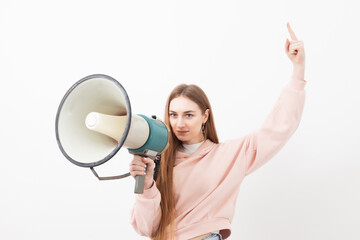 Caucasian young woman student speaks into a bullhorn (loudspeaker) on white background. Reporting important information