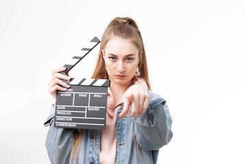 Young emotional woman holding a clapperboard on white background