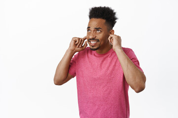 African american guy bothered by loud neighbours. Young man shut ears with fingers, clench teeth...