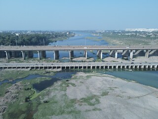Fototapeta na wymiar Cars driving onto Bridge towards City Skyline , Aerial birds eye view tilt up