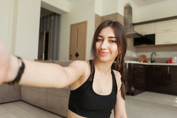 Fototapeta na wymiar Selfie portrait of young fitness woman in living room