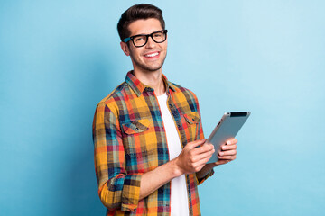 Portrait of attractive cheerful guy geek using device app 5g searching web isolated over bright...
