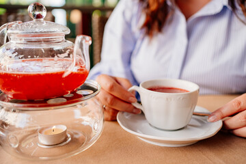 close-up. a woman pours tea into a white mug. serving hot drinks in a cafe