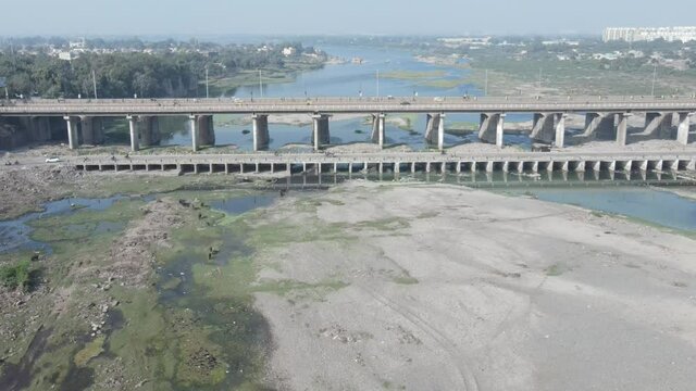Cars driving onto Bridge towards City Skyline , Aerial birds eye view tilt up