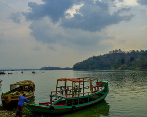 Obraz premium Boat in kaptai lake with beautyfil sky and green background 