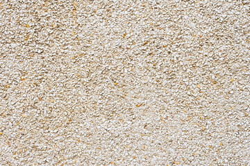 Exterior photograph of a small stone facade of a building.It is a textured background that follows a pattern.Photo taken in horizontal format.