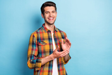 Portrait of attractive cheerful guy clapping palms presentation isolated over bright blue color background