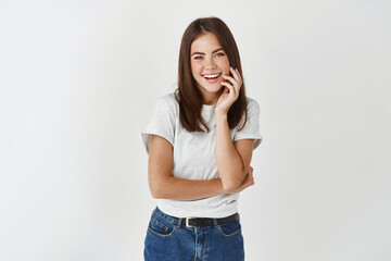 Portrait of young beautiful brunette girl smiling looking at camera over white background