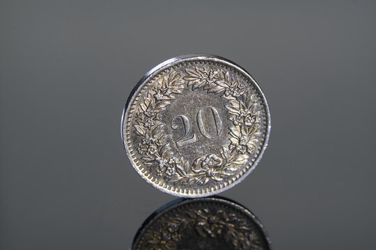 Swiss 20 centimes coin on red background