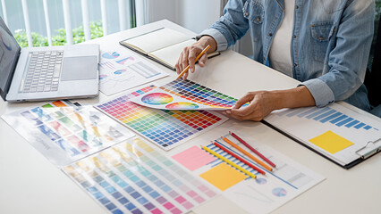 Graphic design and color swatches and pens on a desk. Architectural drawing with work tools and accessories.