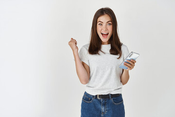 Excited woman winning prize on phone, rejoicing and looking at camera happy, scream of joy over...